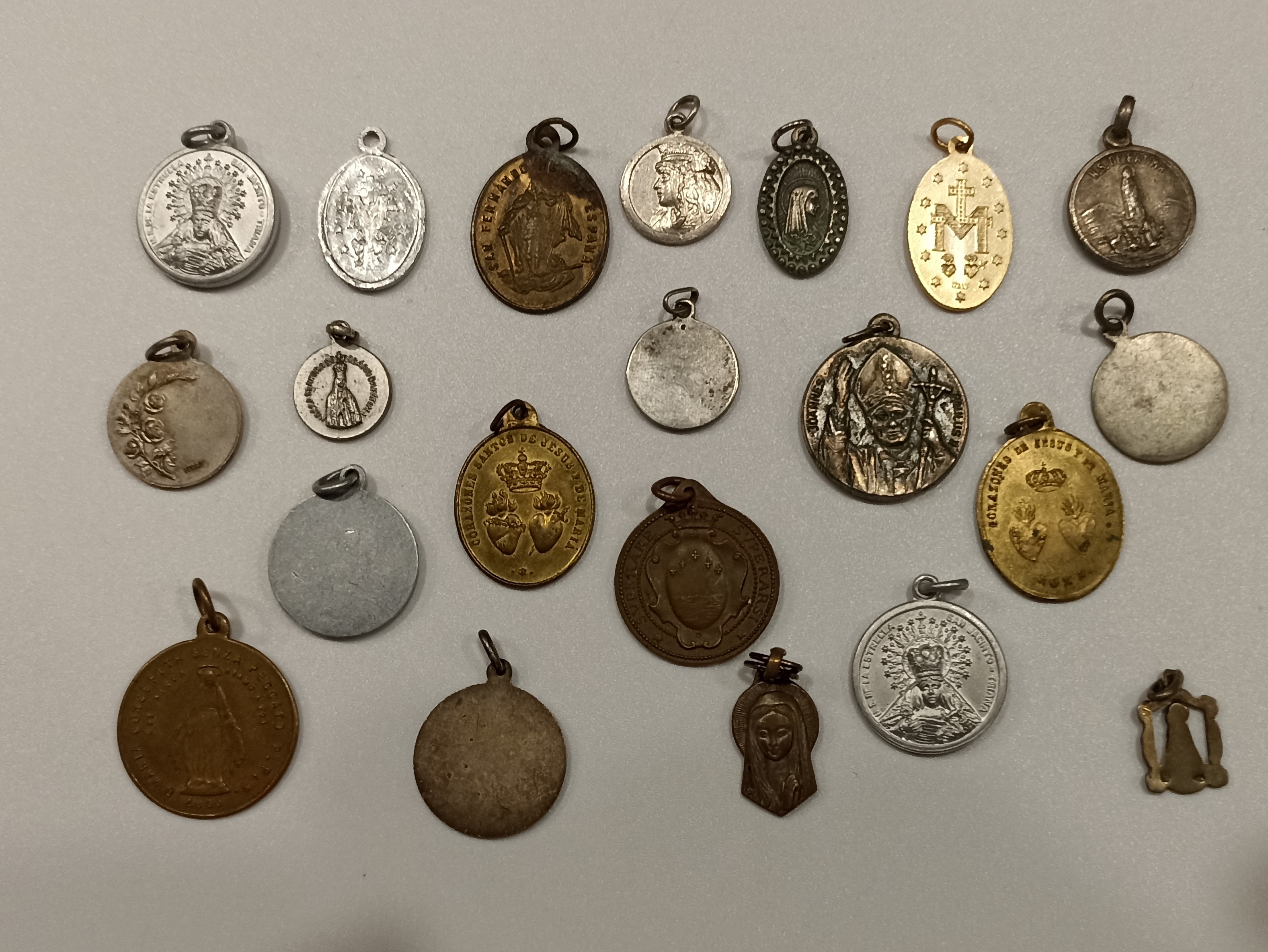 Lote de 21 medallas religiosas. Siglo XX. Diversas advocaciones, en su mayoría sevillanas. 