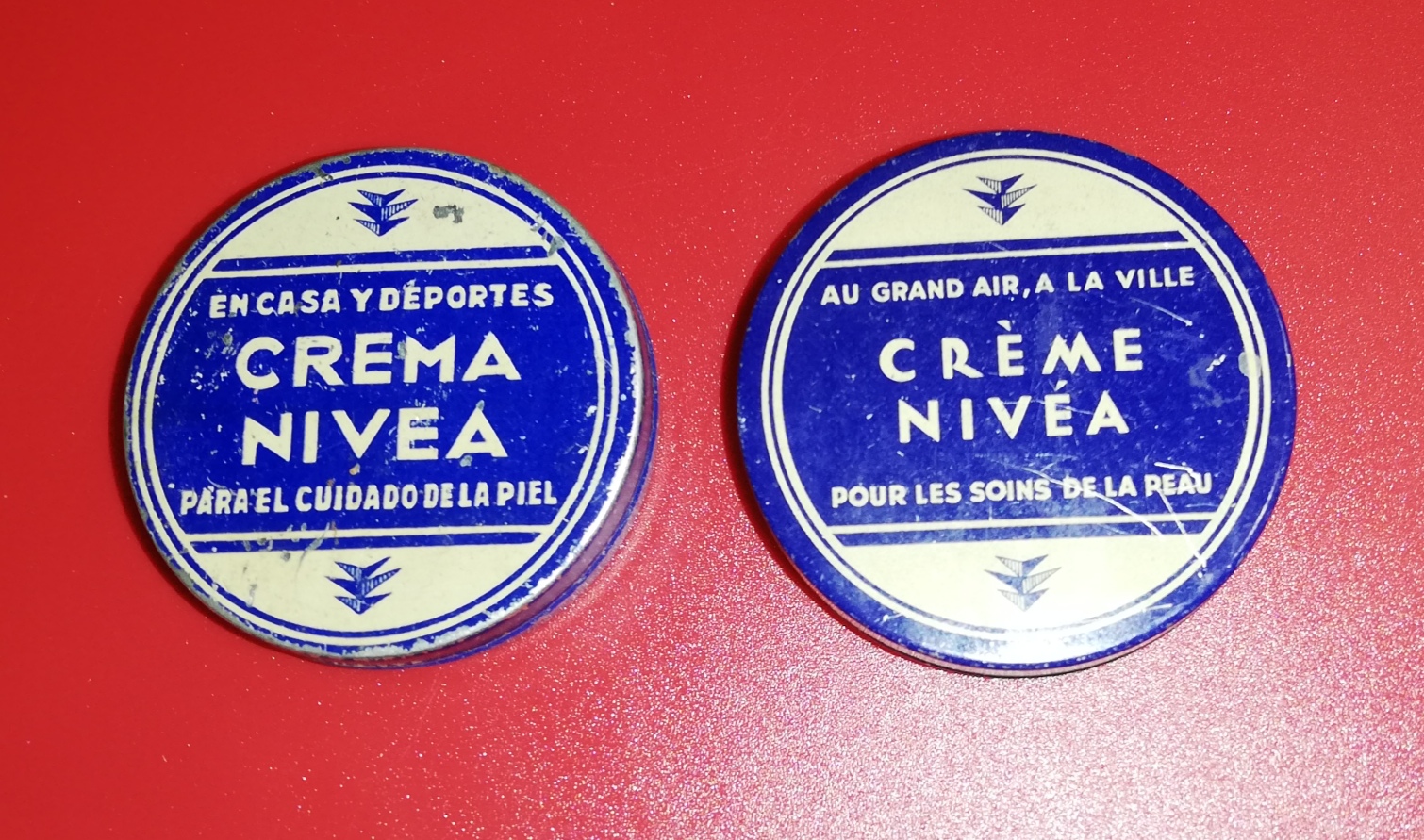 Crema Nivea. Lote de 2 cajas metálicas (diámetro 5 cm.). En español y francés. Mitad siglo XX